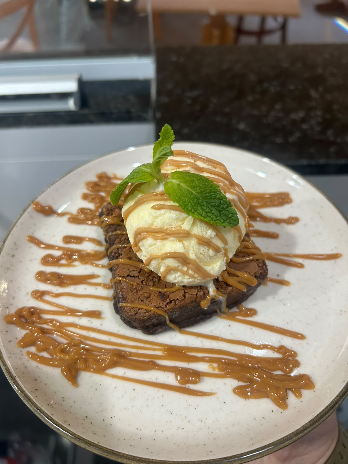 Brownie quente com sorvete de creme, hortelã e calda de doce de leite