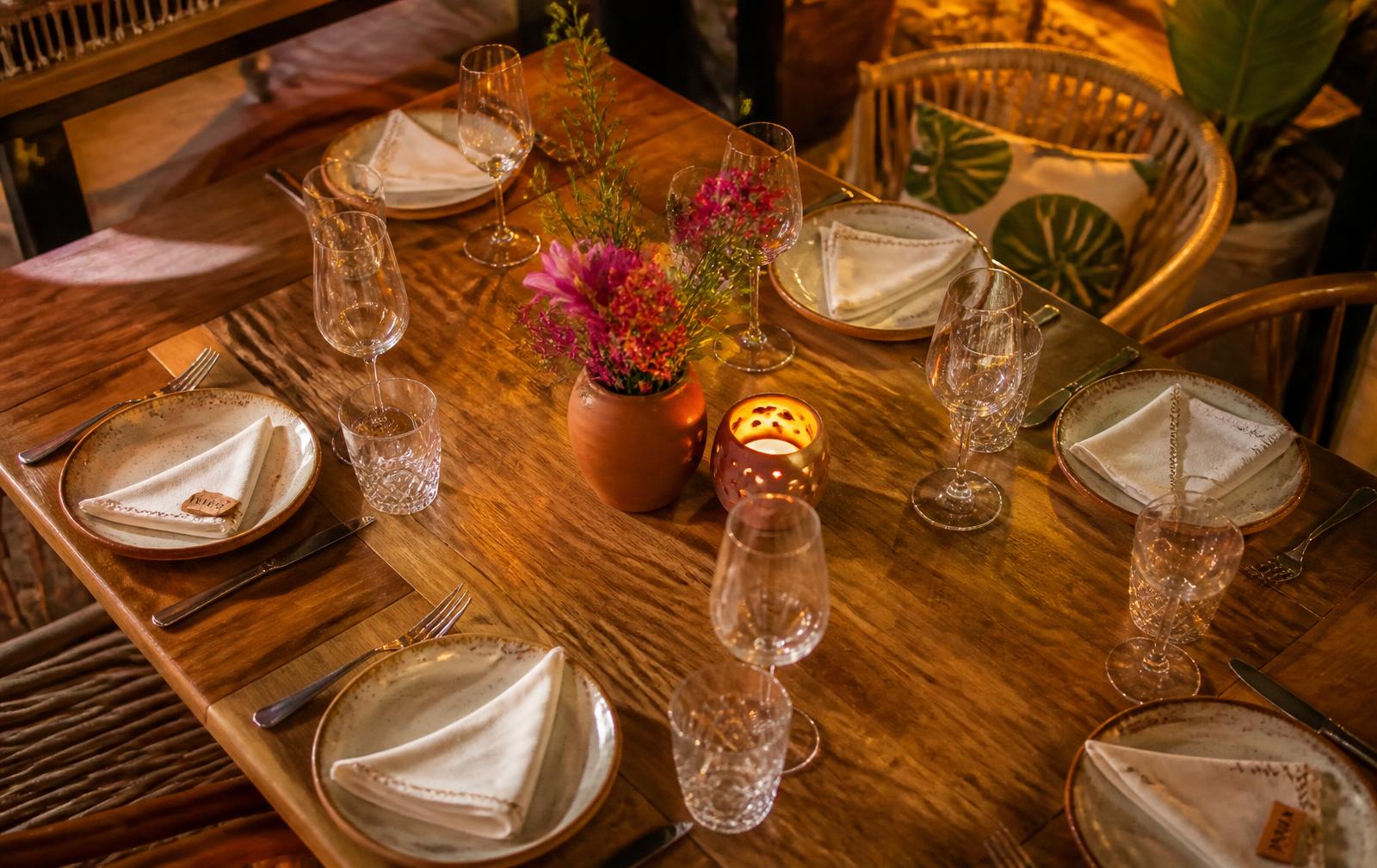 Mesa posta com pratos, copos e flores